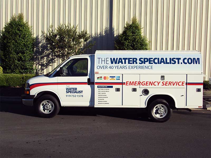 White box truck with The Water Specialist logo parked in front of commercial building
